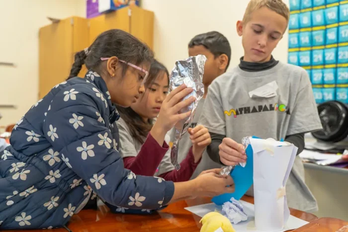 Children in a North Carolina school district work collaboratively on a project. The district has a plan to reduce its magnet themes