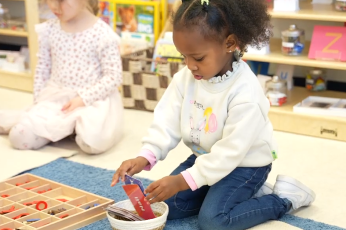 a girl interacts with Montessori materials
