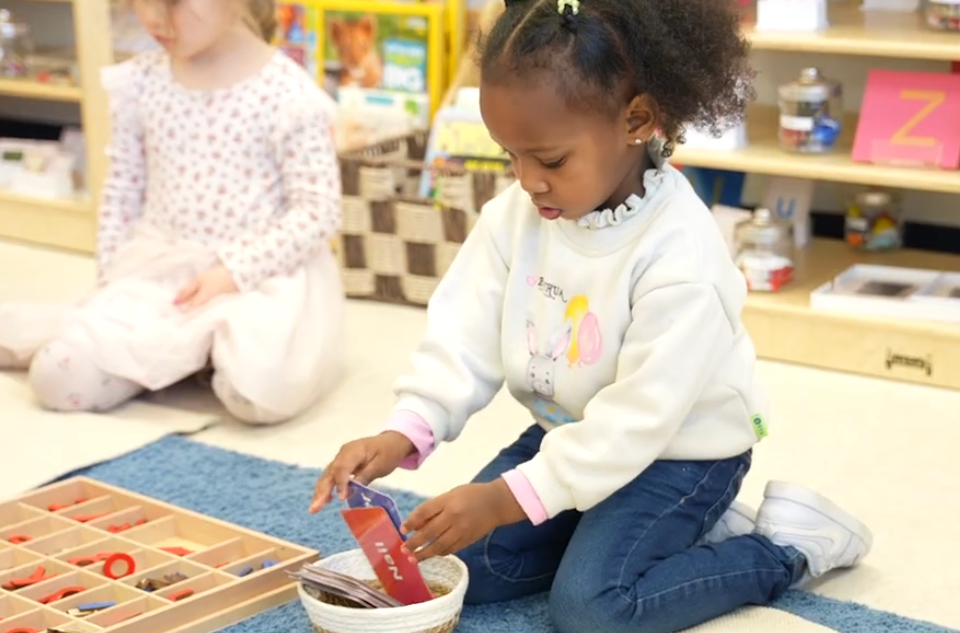 a girl interacts with Montessori materials