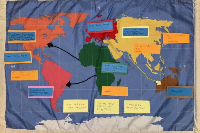 a map of the world with handwritten notes stuck to it