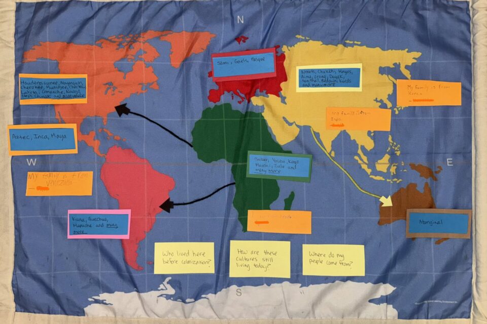 a map of the world with handwritten notes stuck to it